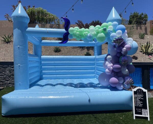 Beautifully Decorated Sky Blue Colored bounce house with Colored Balloons