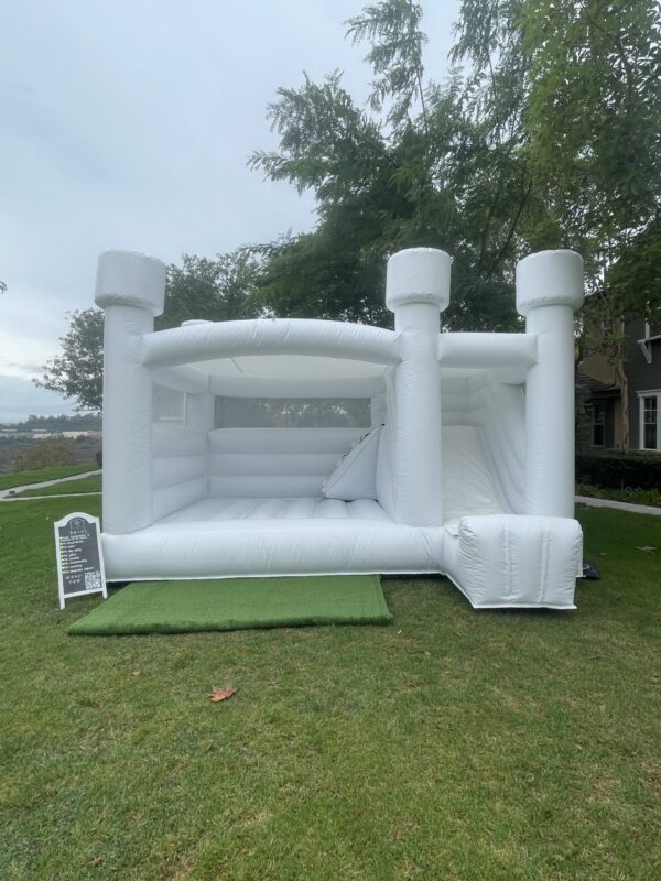 White Colored Combo bounce house placed outside the house